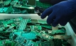 Telephone circuit board parts being disassembled as electronic waste for recycling.