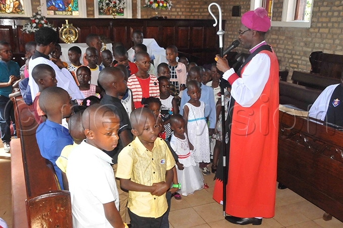 he ishop of nkole iocese ev r heldon wesigwa blessing children who turned up for hristmas prayers at t ames athedral in uharo hoto by bdulkarim sengendo