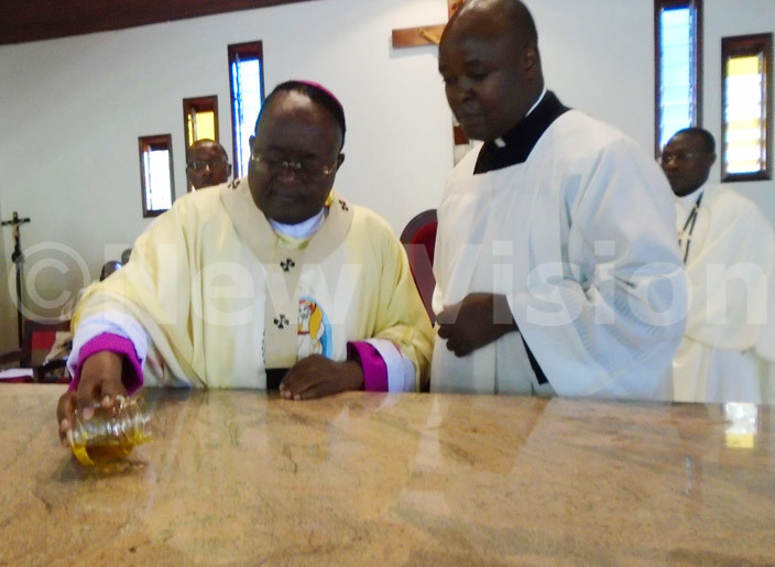  rchbishop wanga anoints the altar of apeeraabulagala atholic hurch during its consecration on aturday