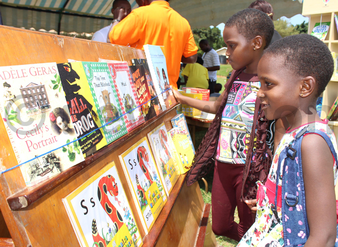 lizabeth dagire and auda uganzi trying to choice a book on the shelf for sale hoto by ony ujuta