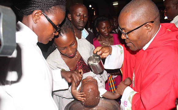 Faaza Emmanuel Kalema ng'abatiza omwana. Faaza Emmanuel Kalema ng'abatiza omwana.