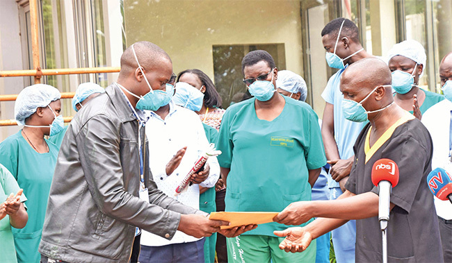  r yarugaba aterana the executive director of ulago ospital ampala hands over certificates of recovery to a representative of 19 patients ealthcare services are among the winners of the lockdown