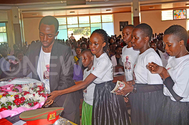  hildren of the late t ol harles damulira laying a wreath on the casket containing the remains of their dad