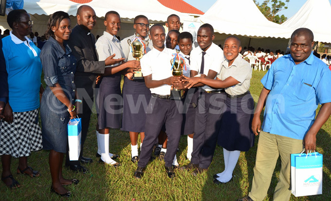  tudents of ugwanya ummit ollege yengera who took third position receive their trophies from r red enga 3rd left