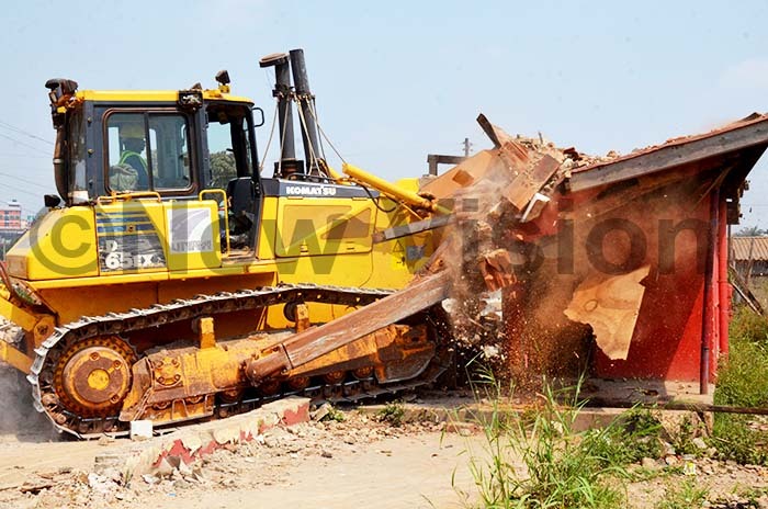   grader clearing a post office building  along sambya road aving way for the construction of the first flyover in ampala by  on uly 26 2019 hoto by adru atumba 