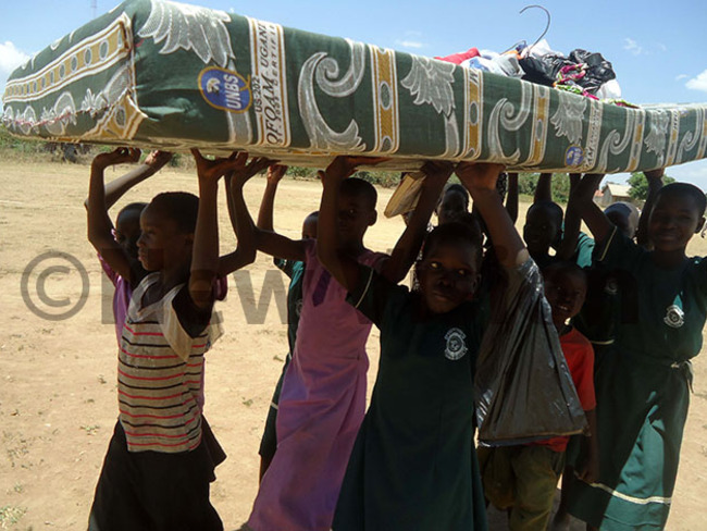  upils of amba primary school help their teacher to carry a mattress to a classroom after the eviction hoto by mmanuel pio