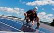 File photo: a worker installing rooftop solar 