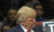 Donald Trump holds a 'Trump Digs Coal' sign during a rally in 2016.