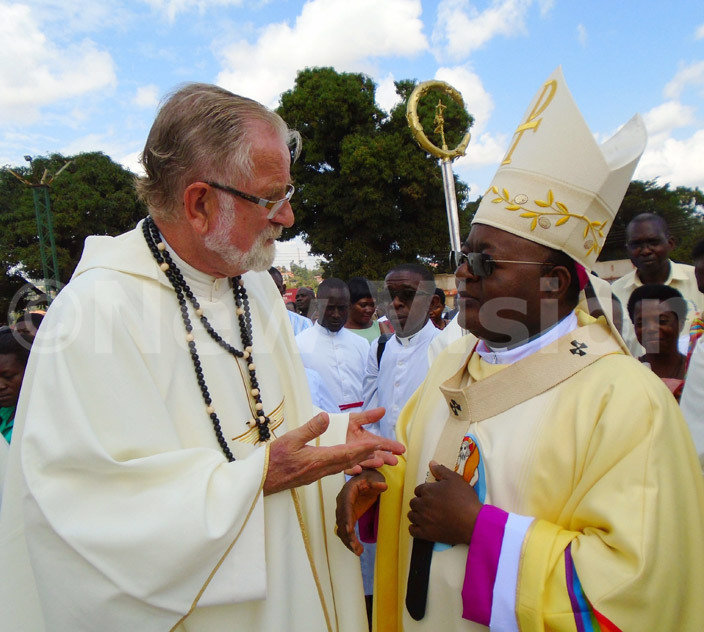  r ooyschuur atongole of the hite athers left chats with rchbishop wanga during the consecration of apeeraabulagala hurch