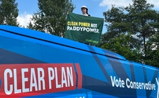 'Clean Power Not Paddy Power': Greenpeace protester climbs on to Tory campaign battle bus