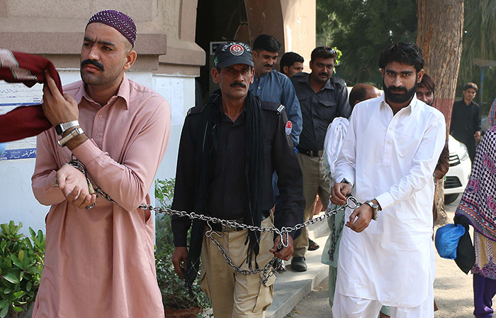  his photograph taken on ctober 17 2017 shows asim  brother of slain social media celebrity andeel aloch and his cousin who are accused of killing her are escorted by policeman as they arrive at a local court in ultan  hoto   irza 