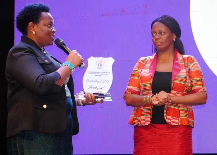   eace utuuzo inister of tate for ender and ulture hands over an award to the xecutive irector  atricia unabi as the best outstanding ivil ociety rganisation