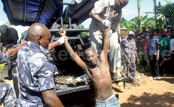 Angulu bwe baali bamusitula okumussa ku kabangali ya poliisi. Angulu bwe baali bamusitula okumussa ku kabangali ya poliisi.