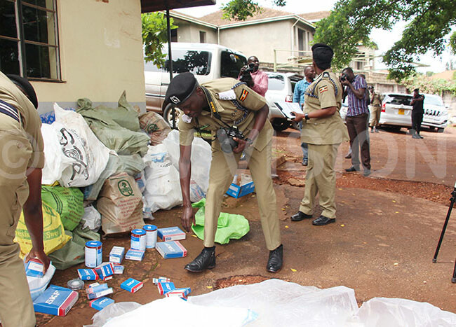  olice officers showcasing some of the raided counterfeits goods at nterpol headquarters in ololo ampala
