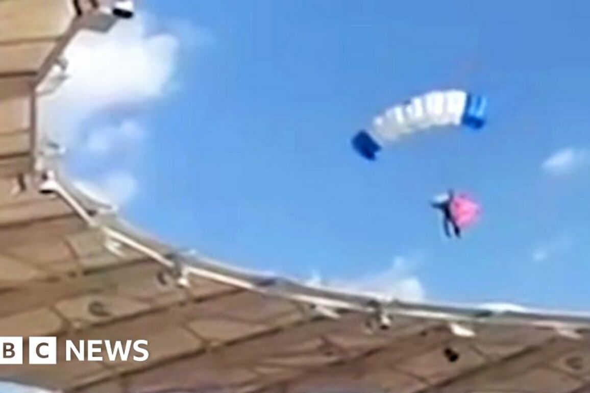 Moment parachutist left dangling on stadium roof