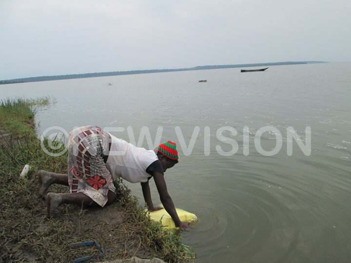 A resident risking drawing water from the crocodile infested Lake Edward shores in Katwe-Kabatoro town