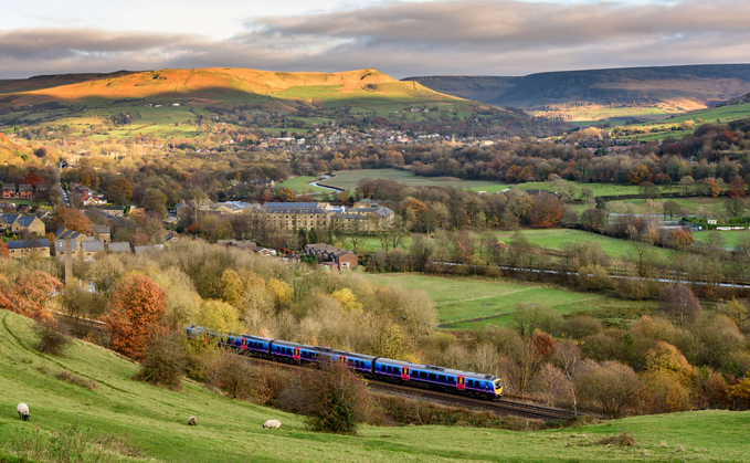 Passenger train passing through countryside near greater Manchester, England | Credit: iStock