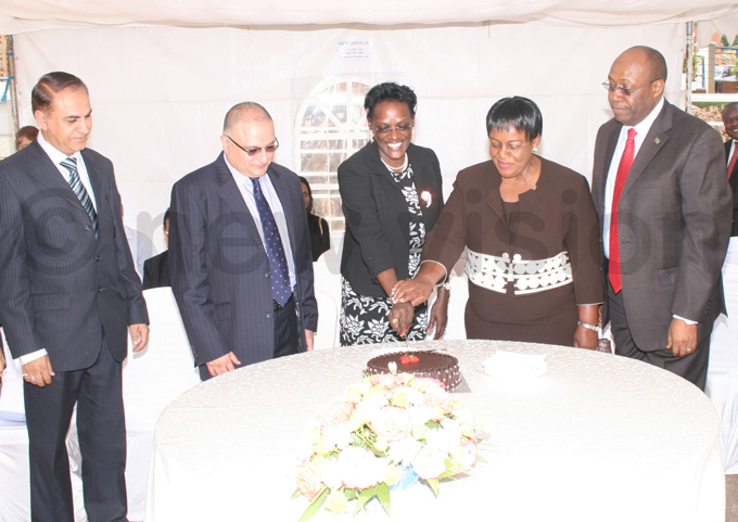  xim ank board chairperson arah agalaaliwo 2nd  leads others in cutting the ceremonial cake hoto by yet kwera