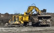 A hydraulic shovel and truck work at a Suncor oil sands mine in Fort McMurray