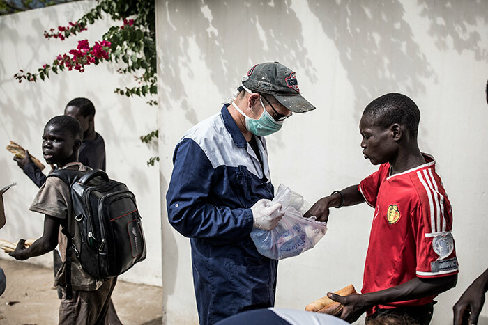   worker from illage ilote hands out water and sandwiches to treet children in akar on pril 10 2020