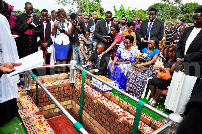  hristine uwanguzi the wife of the late amson uwanguzi together with her children throw flowers on the casket during their fathers burial at omamboga on ayaza road on 8316    