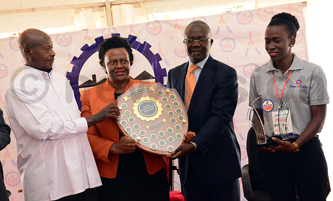 resident useveni hands over the best overall exhibitor award to teel  ube ndustries hoto by ddie sejjoba