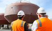 Carnegie workers standing before a wave turbine asset 