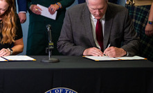 Alaska governor Mike Dunleavy and Permitting Council executive director Emily Domenech sign the MOU