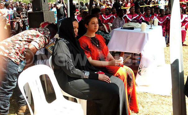 adioss widow in red with a friend at the funeral