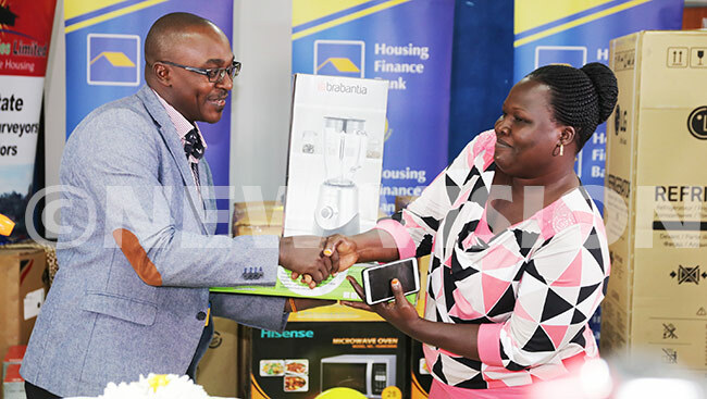   winner receives a blender from aul uwagaba head of business and nstitutional banking at 