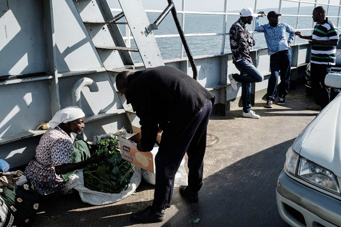  man buys vegetables on the ferry boat sailing from uanda tieno to bita  hoto