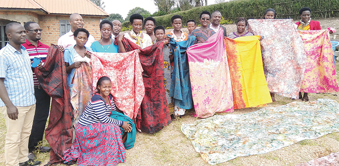 embers of a womens group display fabrics they made with  support eneficiaries are selected through a community participatory process that involves local council leaders