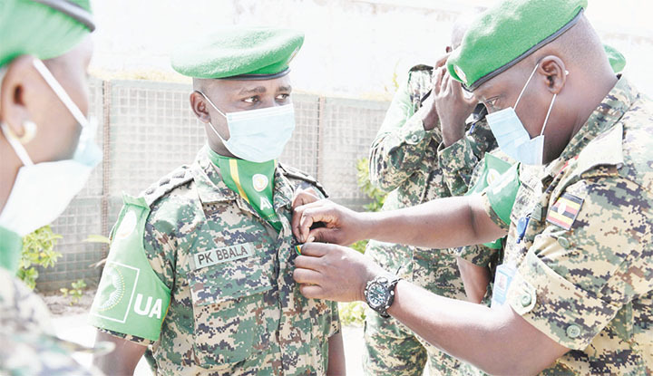 A senior military officer pinning a medal on a Battle Group 27 officer