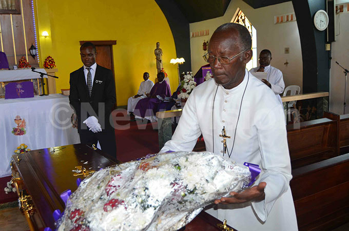  ro eter azzekulya places a wreath on the casket bearing the remains of ro irangwa during the funeral service at ount t heresa hapel isubi on ednesday