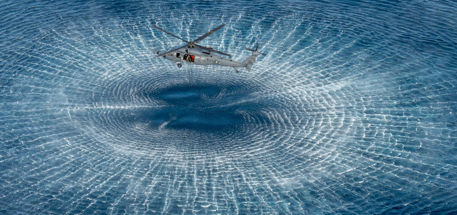 An airman pulls a ladder into an HH-60W Jolly Green II helicopter during a simulated rescue operation as part of Exercise Distant Fury Stallion/Steel Knight off the coast of California, Dec. 9, 2024