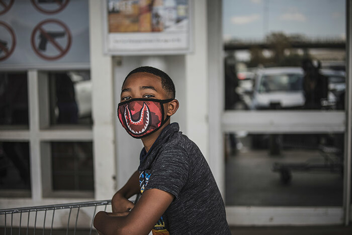 boy wears a face mask as a preventive measure against the spred of the 19 coronavirus as he queues outside akro in oweto ohannesburg on arch 24 2020 outh frican resident yril amaphosa on arch 23 2020 announced a 21day national lockdown to start later this week to contain the spread of the 19 coronavirus which has affected more than 400 people and ordered the military to enforce the ban hoto by