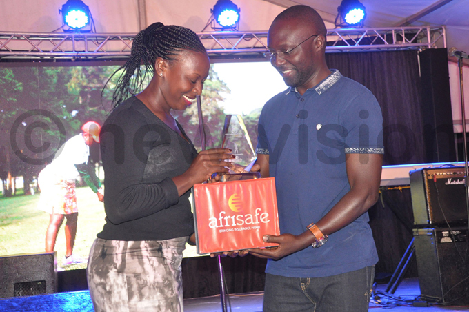  eace abasweka  receives the ladies roup  winners prize from ntebbe lub vice president scar emawere hoto by ichael subuga