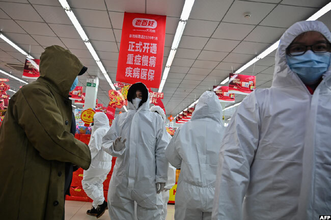  harmacy workers wearing protective clothes and masks serve customers in uhan on aturday