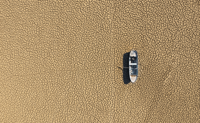 Aerial view of a fishing boat on a dry lakebed | Credit: iStock