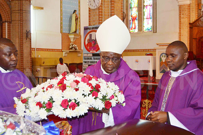  ishop aul semwogerere lays a wreath on the casket containing the remains of the late mubitookati dyeri laxeda yakairu during the requiem mass at ubaga athedral