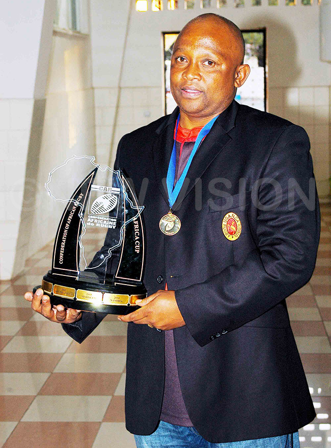  ganda rugbys winningest coach avid ebolla with the trophy 