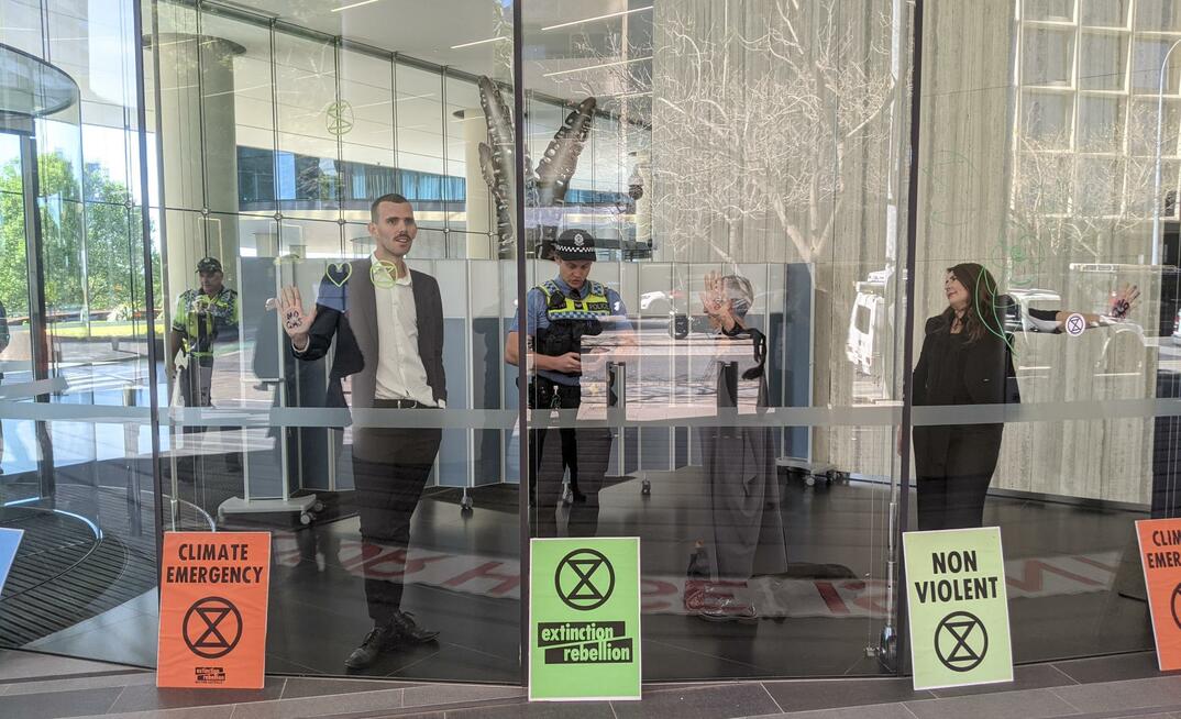  Protestors glued themselves to the lobby of Woodside Petroleum headquarters in Perth. Credit: Mark Tilly