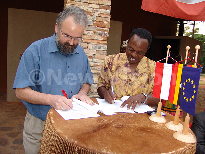he ead of ission ustrian mbassy rawz reiwie ser left sign a emorandum of nderstanding between ustria and dere roup with the roups xecutive irector tephen wengyezi   right at dere entre on eb 18 2005