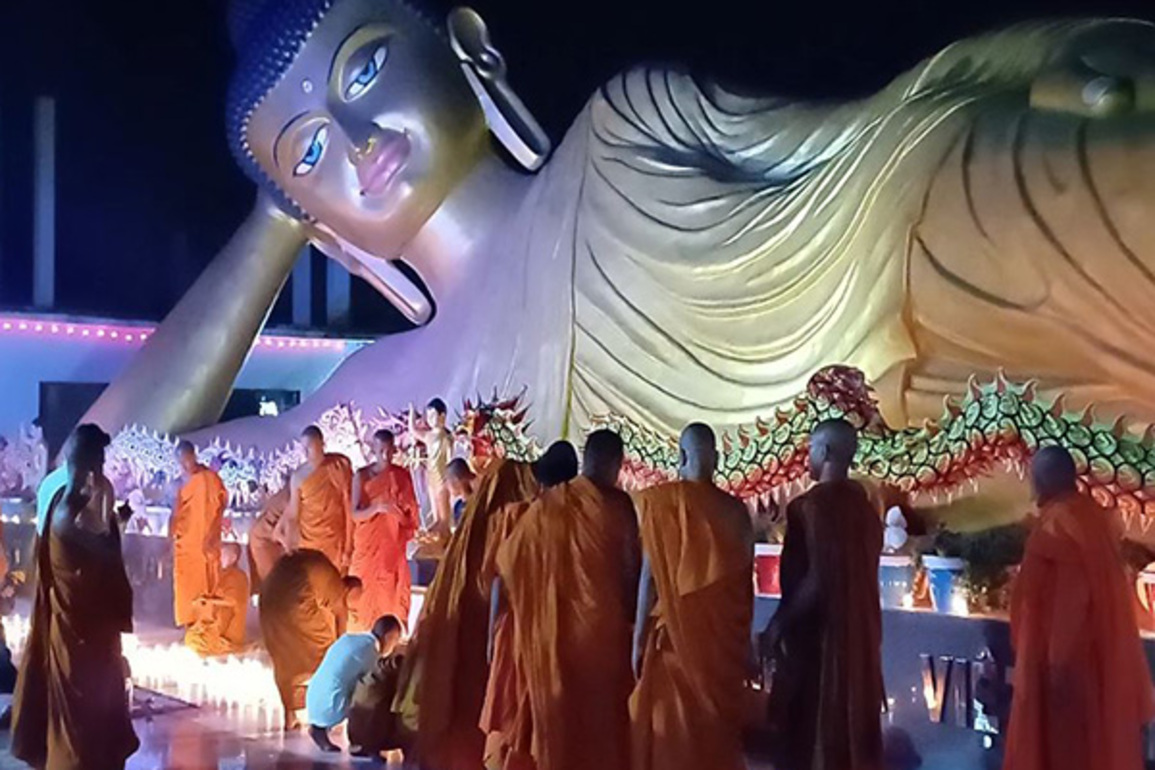Bihar: Monks light candles near India's largest reclining statue of Lord Buddha