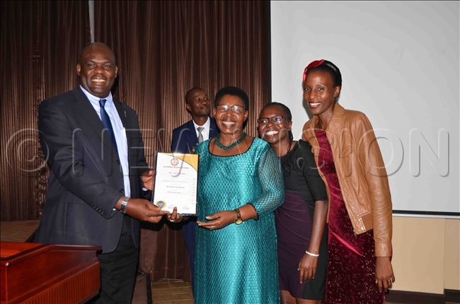  hibita hands over an accolade to on iria atembe as members of her family cheer