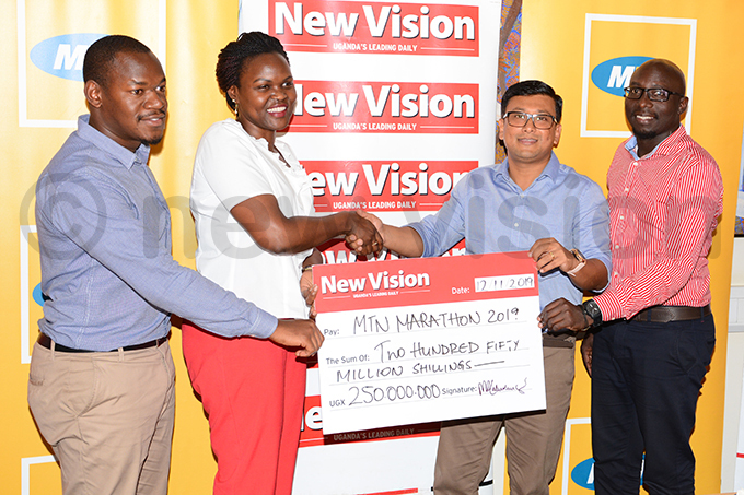 s omdev en 2nd right and ohn aul kwi right receive a sh250m dummy cheque from ision roups oseph yaruhanga left and orothy uttu hoto by ichael subuga