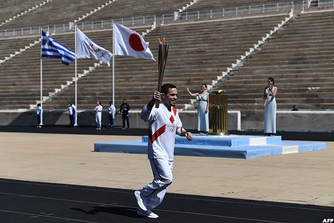  n athlete carries the lympic torch during one of the last relays ahead of the olympic flame handover ceremony for the 2020 okyo ummer lympics on hursday in thens reece