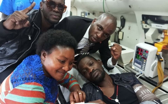 Bobi nga yeekebejjebwa mu ddwaaliro nga ky'ajje ayimbulwe. Wano yabadde n'omubaka Winnie Kiiza, Looya we Andrew Karamagi, n'omuyimbi wa Fire Base, Nubian Lee nga bajaganya olwa Bobi Wine okuyimbulwa. EKIF: ANDREW KARAMAGI Bobi nga yeekebejjebwa mu ddwaaliro nga ky'ajje ayimbulwe. Wano yabadde n'omubaka Winnie Kiiza, Looya we Andrew Karamagi, n'omuyimbi wa Fire Base, Nubian Lee nga bajaganya olwa Bobi Wine okuyimbulwa. EKIF: ANDREW KARAMAGI